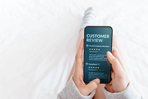 woman-lying-bed-reading-online-review-via-smartphone